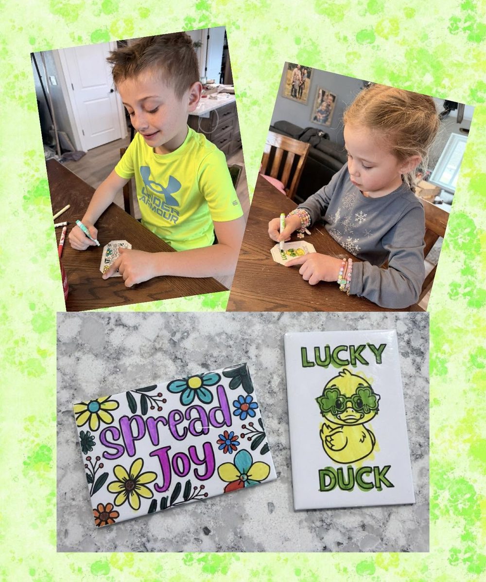 Kids coloring dry-erase magnet tiles, with two finished Color-It-Yourself magnets on the counter